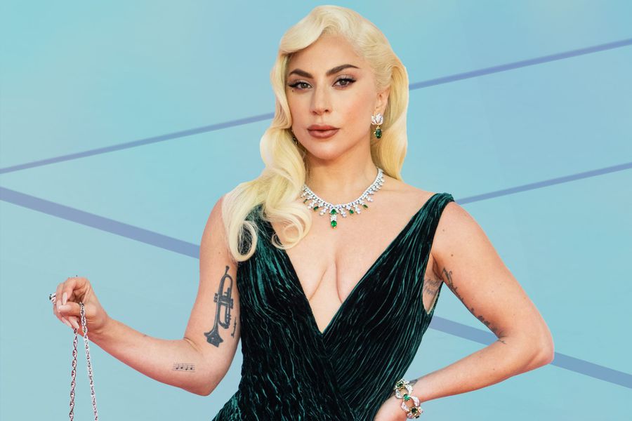 Lady Gaga wearing an emerald dress at the EE British Academy Film Awards 2022 against a tennis court background