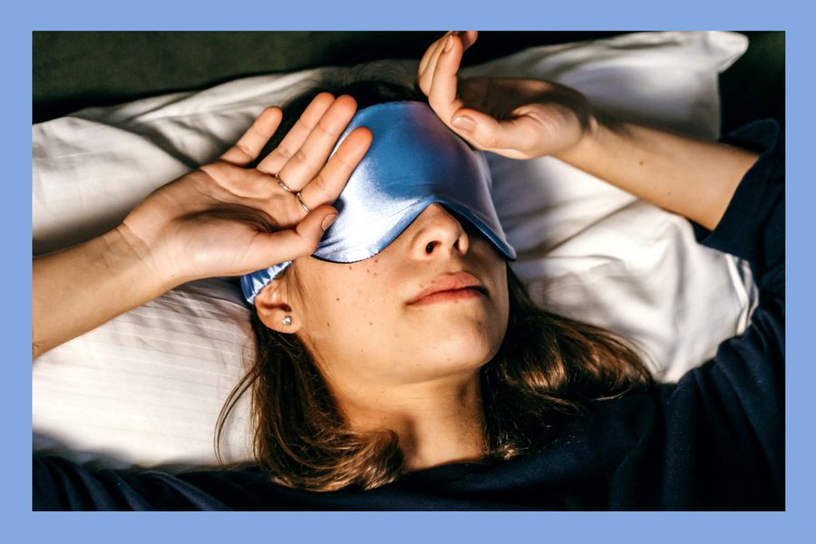 Person sleeping in darkness with a blue silk sleep mask on