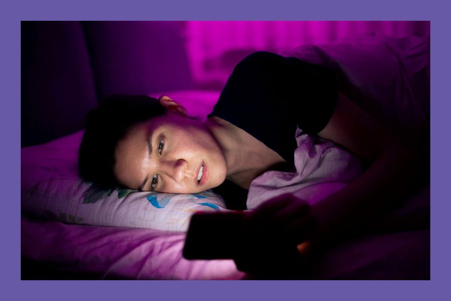 Woman laying in bed using smart phone