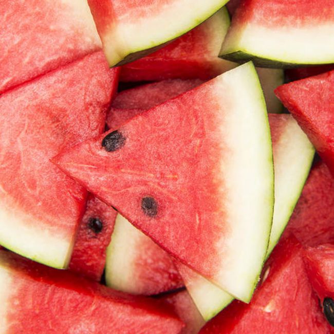 watermelon food to stop bloating: an overhead shot of haphazardly stacked slices of watermelon